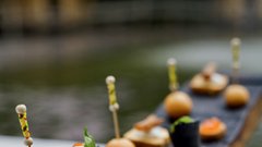 Pikolove predjedi, postrežene na kosu recikliranega soda: kaviar na hrustljavih kruhkih, tople kroglice iz parmezana, črn sezamov kornet, polnjen z mocarelo, baziliko in paradižniki … 