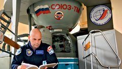 Vesoljski turist Guy Laliberte preučuje Sojuzov priročnik.