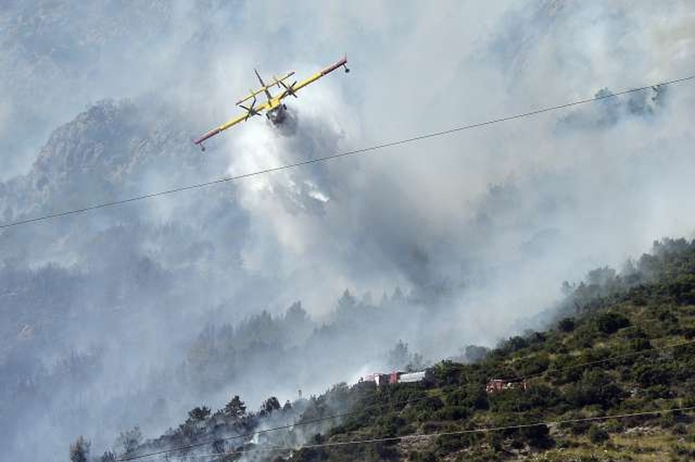 Nedaleč od Splita gasilcem v boju s požarom preglavice delata močan veter in nedostopen teren (foto: Hina/STA)