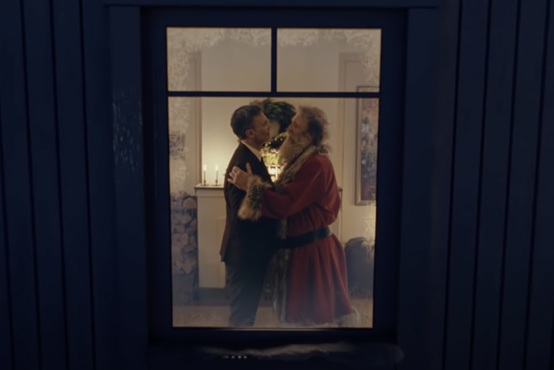 [VIDEO] Viralen božični oglas, v katerem Božiček poljubi moškega, postal neverjetno priljubljen
