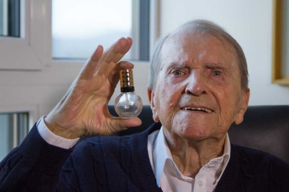 Peter Florjančič, fotografiran tik pred 101. rojstnim dnem, ob snemanju intervjuja za razstavo v ZDA. V roki drži izum - razpršilec za parfum.