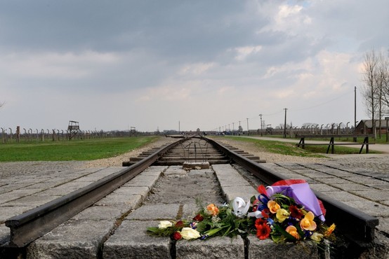 Holokavst, sočutje in svečka na grobu nesrečnih Romov, ki so bili pobiti leta 1942