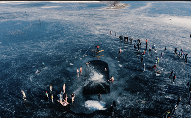 Akrobati Dunking Devils z rusko gugalnico skakali v zaledenelo Cerkniško Jezero