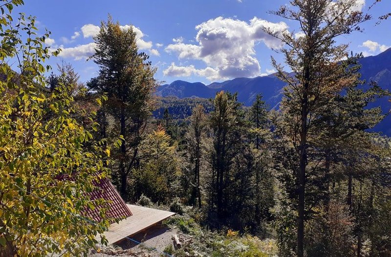 Pogled na glamping hiško pred katero se na jug odpira pogled na Trnovski gozd.