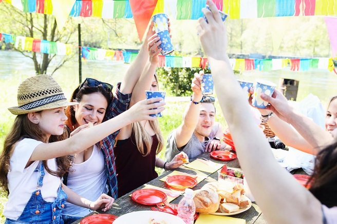 Zbrana družba nazdravlja na pikniku.