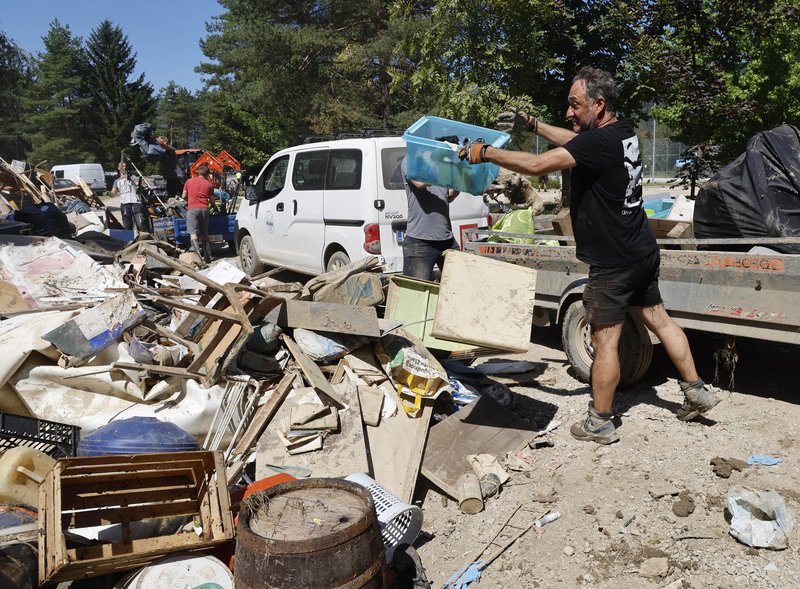 Prostovoljci pri čiščenju po katastrofalni ujmi.