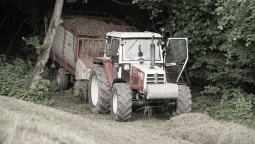 Huda delovna nesreča na Dolenjskem: moški, ki ga je traktor stisnil ob drevo, podlegel poškodbam