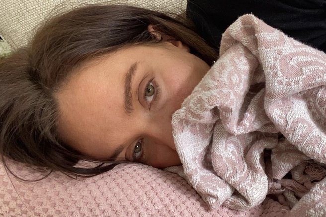 Ženska počiva v postelji.