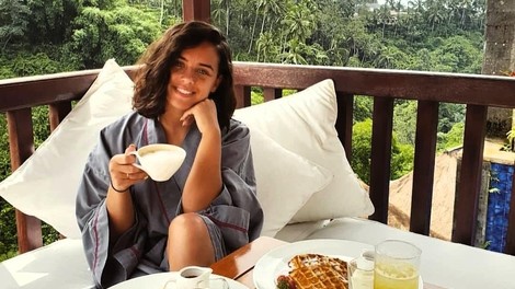 Lepo dekle zajtrkuje na terasi.