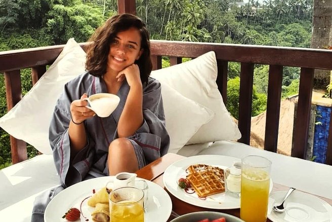 Lepo dekle zajtrkuje na terasi.