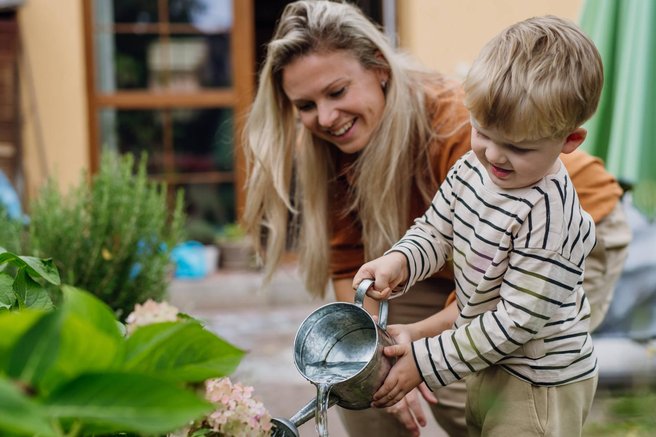 starševstvo mati otrok vrtnarjenje zalivanje rože rastline vzgoja