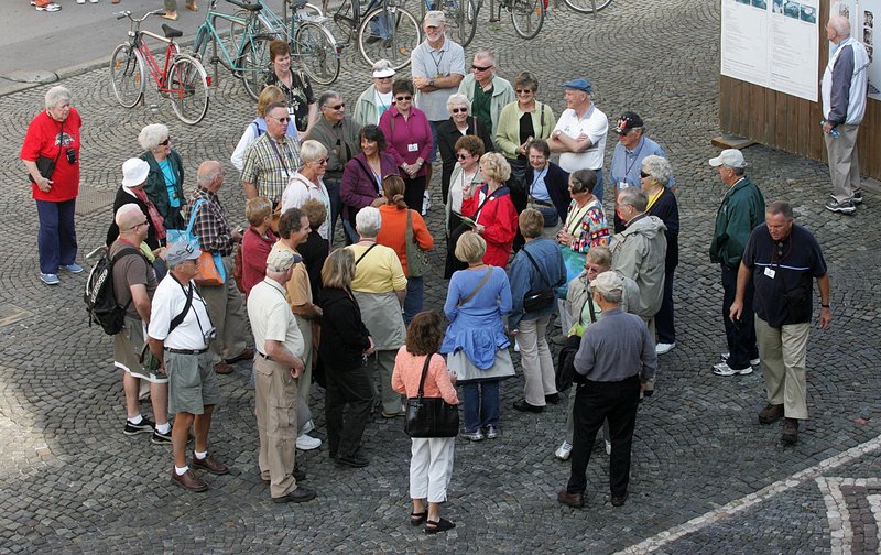 Turisti v centru Ljubljane na vodenem ogledu starega mestnega jedra.