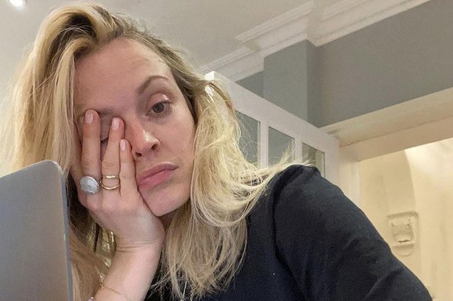 Utrujena in neprespana ženska sedi pred računalnikom