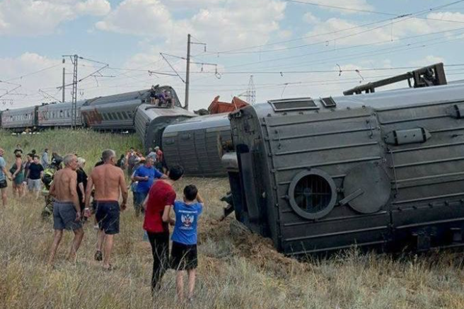 Grozljivo: vlak z 800 potniki trčil v tovornjak, več vagonov razmetalo naokoli
