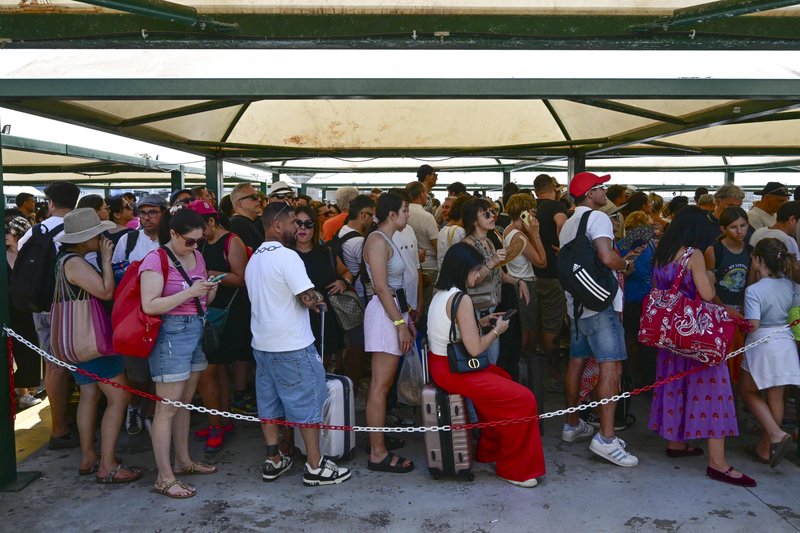 Gneča turistov, ki čakajo, da se vkrcajo na trajekt do otoka Capri.