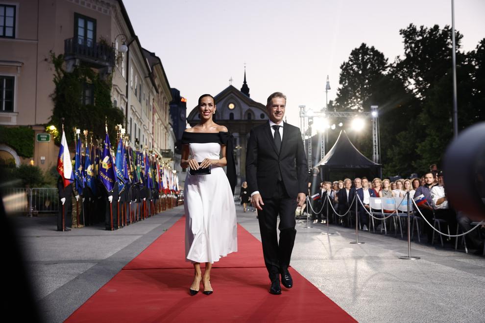 Največ pozornosti sta tudi letos pritegnila premier Robert Golob in njegova partnerica Tina Gaber. Gabrova je nosila elegantno črno-belo obleko …